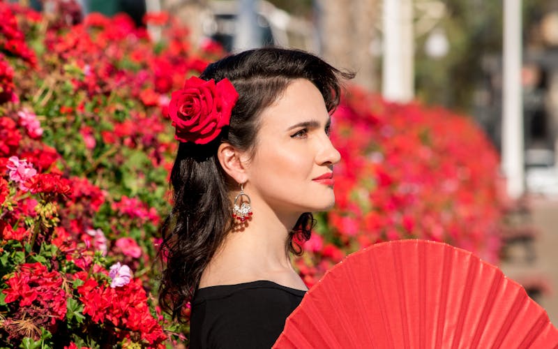 Flamencotänzerin mit Rose im Haar und Fächer in der Hand