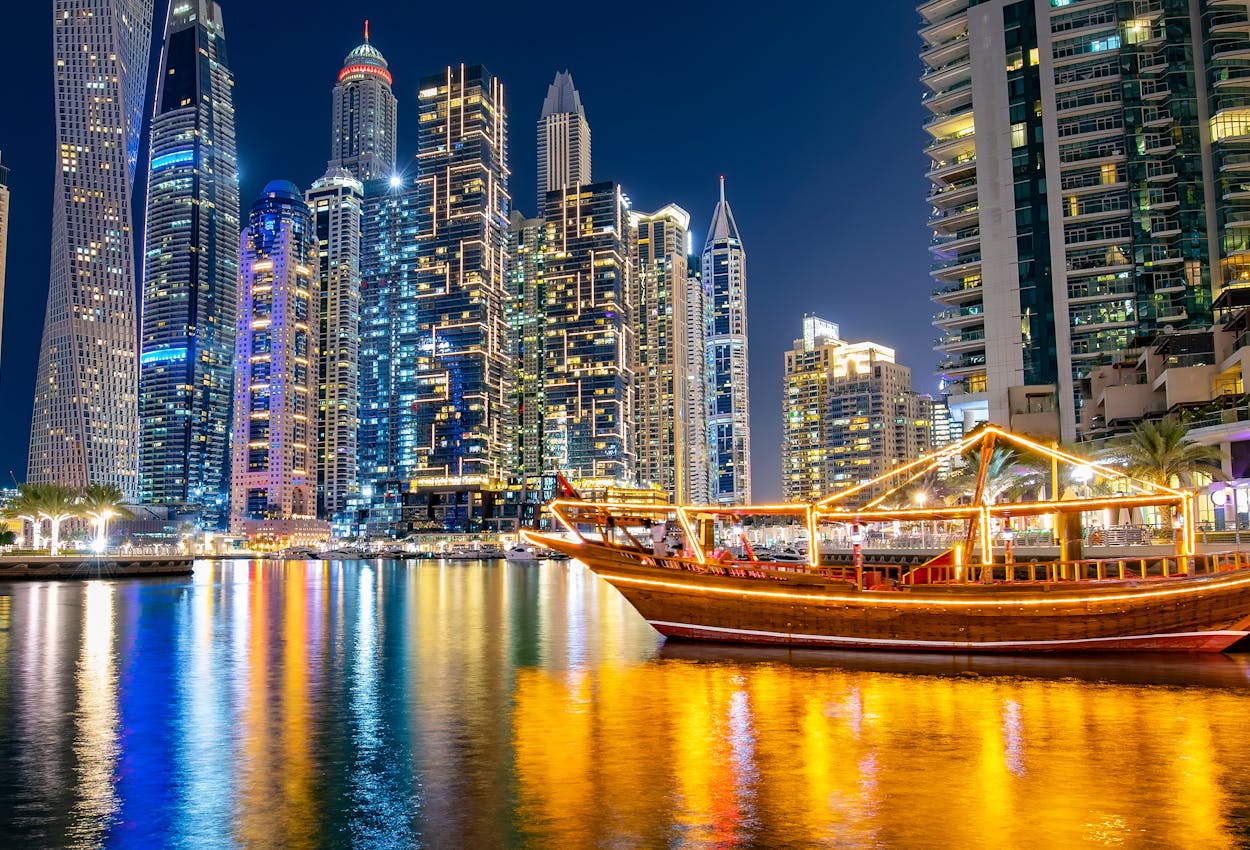 Die Marina Bay in Dubai am Abend mit einer Dhow