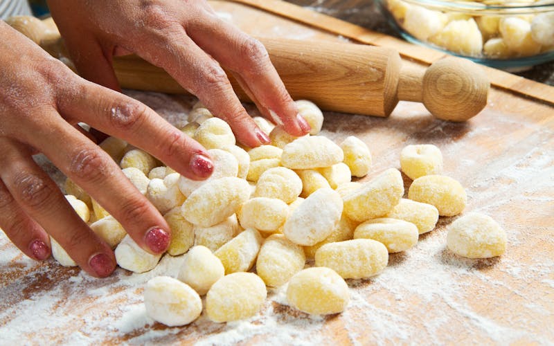Bäckerin bestäubt Gnocchi mit frischem Mehl