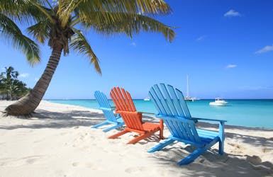 Farbige Holzstühle stehen am Strand