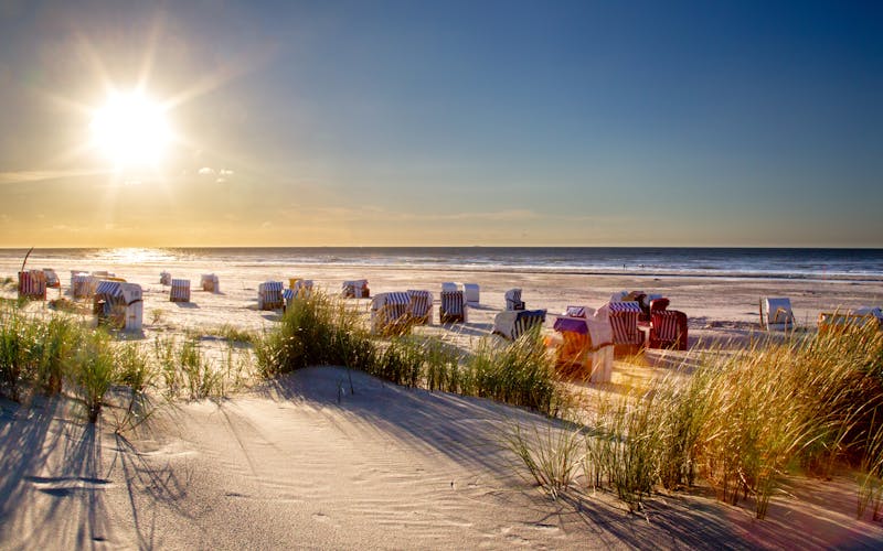 Sandstrand mit Strandkörben bei Sonnenaufgang