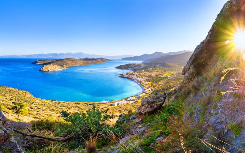 Blick zwischen Felsen auf traumhaft blaues Mittelmeer und kleiner Insel