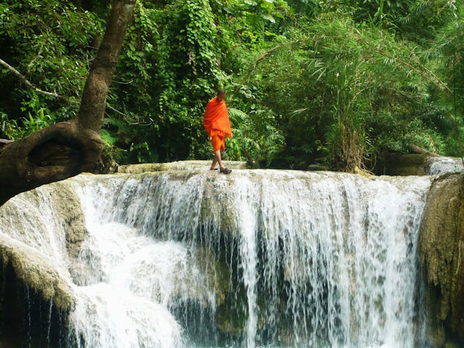 Mönch geht an Wasserfall-Kante entlang
