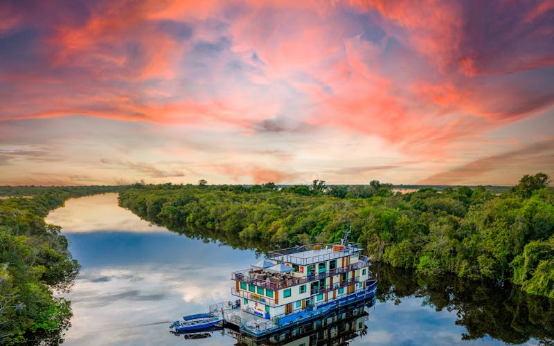 Kleines Schiff auf Amazonas bei Sonnenuntergang