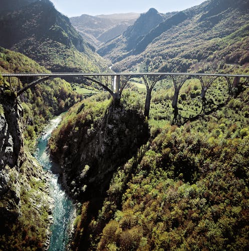 Imposante Brücke über Flusslauf verbindet zwei Gebirgsketten