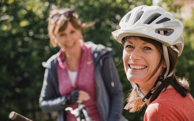 zwei Damen lachend mit Fahrradhelm